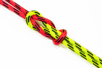 Reef, Hercules, square, double or brother hood Binding knot binding two colored (red and green) ropes. nautical loop used to secure rope or fishing line around an object. Isolated on white background