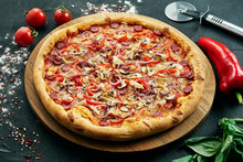 Pizza With A Large Number Of Toppings: Hunting Sausages, Onions, Mushrooms, Salami, Cheese And Bell Pepper. Pizza In Composition With Ingredients On A Black Background