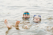 Two Brothers Wearing Goggles Having Fun In Water