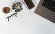 © Cavan Images - Top view of workspace with laptop, phone, glasses, notepad, coffee.