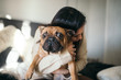 © Cavan Images - A tattooed woman hugging her cute puppy. Happy moment between pe