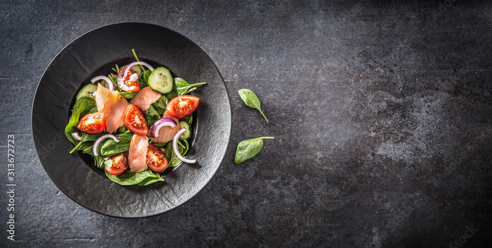 Salmon salad with vegetable in plate on dark kitchen table - Top of view - obrazy, fototapety, plakaty 
