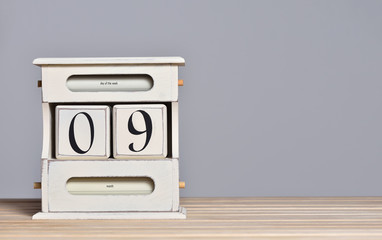 Fototapete - Desktop wooden retro calendar with day number 9. Calendar template for writing a holiday date and free text space
