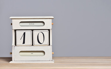 Fototapete - Desktop wooden retro calendar with day number 10. Calendar template for writing a holiday date and free text space