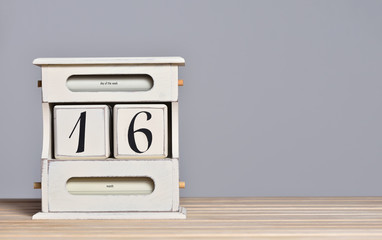 Fototapete - Desktop wooden retro calendar with day number 16. Calendar template for writing a holiday date and free text space