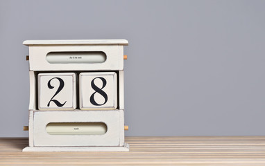 Fototapete - Desktop wooden retro calendar with day number 28. Calendar template for writing a holiday date and free text space
