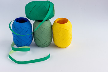 Rolls of decorative tape on a light background. Coils with plastic colourful ribbons for gifts. Packaging tape reels.