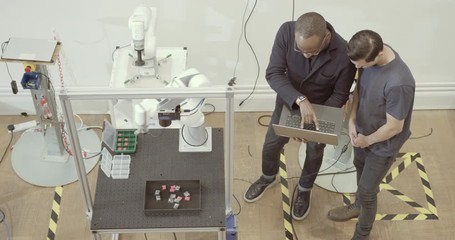 overhead shot of team programming a robotic arm