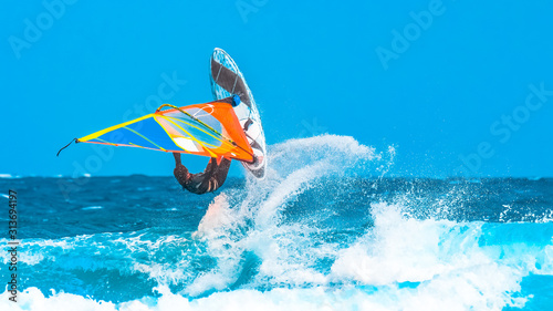 Fototapety Windsurfing  sporty-wodne-windsurfer-bawi-sie-wykonujac-akrobatyczny-skok-na-falach