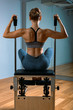 © Georgii - Pilates woman in a reformer doing stretching exercises in the gym. Fitness concept, special fitness equipment, healthy lifestyle, plastic. Copy space, sport banner for advertising
