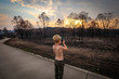 Young boy taking photos of aftermath of the 2019/2020 bushfire season in New South Wales, Australia