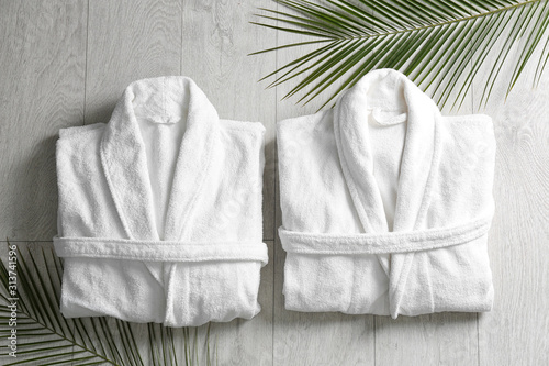Fotografía Flat lay composition with clean folded bathrobes on light wooden background