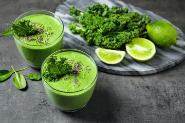 Tasty kale smoothie with chia seeds on grey table