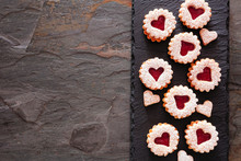 Valentines Day Linzer Jam Cookies With Heart Shapes. Top View Side Border On A Dark Slate Serving Platter. Copy Space.