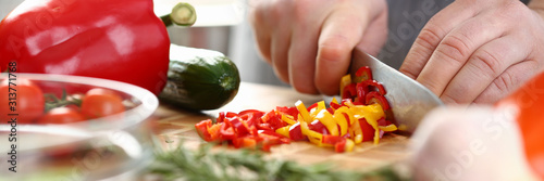 Fotografía Male cook in apron cut red and yellow pepper