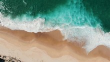 Aerial View Of Drone Flying Above Beautiful Beach With Views Of Ocean Waves And Water Crashing On To Sandy Beach From Top Angle