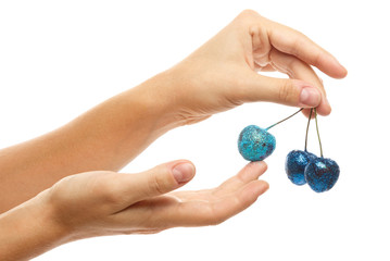 Wall Mural - Female hands and cherry berries covered with a colorful glitters