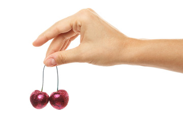 Female hand and cherry berries covered with a colorful glitters