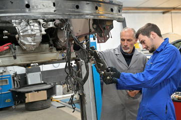 Apprentice with instructor working on vehicle