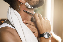 Man Shaving His Beard With A Straight Razor
