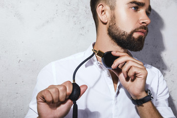 Handsome bearded man is using atomizer nozzle with perfume