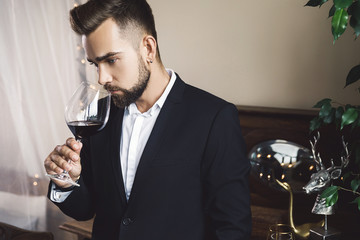 Wall Mural - Handsome bearded man with a glass of red wine