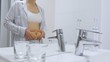 © di_media - Woman With Postpartum Belly Looking At The Mirror In Bathroom.