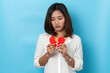 © suriya - asian woman holding broken paper red heart ,valentine concept isolated on blue background