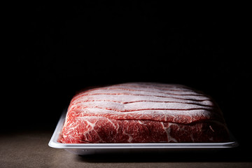 Frozen shabu shabu meat on black background