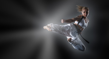 Wall Mural - Composite image of karate girl jumping