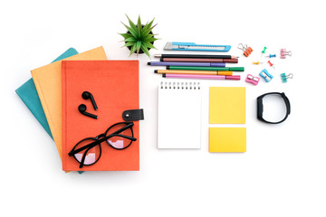 Wall Mural - Work space education and back to school concept on white modern table desk with stack of book and blank note pad, earphone and sticky note, pin and paper clip, flat lay, Top view with copy space