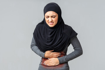 Poster - Muslim girl in headscarf suffering from menstruation pain