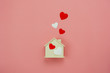 © osabee - Table top view aerial image of decoration valentine's day background concept.Flat lay essential items colorful pastel love shape with wooden house on modern rustic pink paper.Mock up creative design.