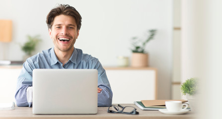 Poster - Happy Employee Smiling At Camera While Working On Laptop In Office