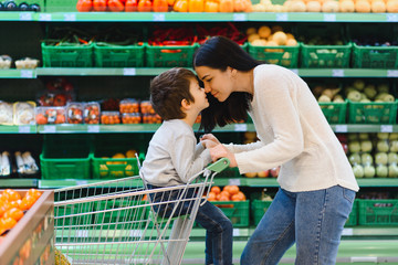 Mother and child shopping at farmer's market for fruits and vegetables