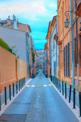 Wall Mural - Narrow street with orange typical houses with bright blue sky - Aix en Provence, France