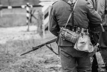 German Soldier During The Second World War In Uniform With A Rifle And Bayonet With A Knife. Black And White Photography