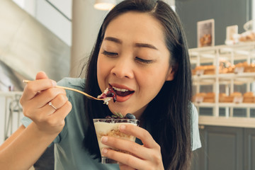 Woman is eating her cake in the bakery cafe.