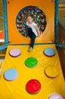 © moodboard - Young girl climbing down ramp in soft play centre