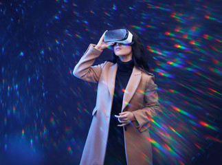 Wall Mural - beautiful woman in fashionable clothes over dark background. girl in glasses of virtual reality. aug