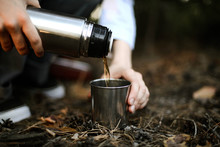 Close-up Of Woman Pouring Tea From Insulated Drink Container Int