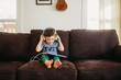 © Cavan Images - Young boy putting on headphones and using tablet at home