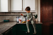 © Cavan Images - Young boy making strawberry and banana smoothie in kitchen