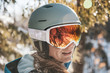 © Cavan Images - Woman in ski goggles and helmet in backlit snow scene in New Hampshire