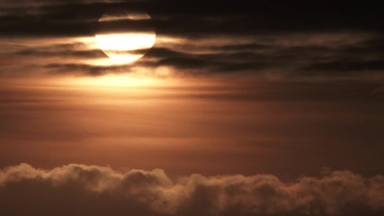 Wall Mural - Sun Shines Bright Behind Dark Cloudscape Real Time