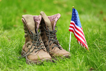 Military Boots And USA Flag Outdoors. Memorial Day Celebration
