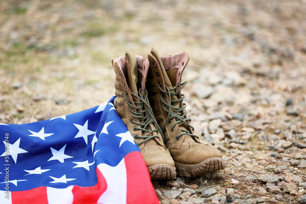 Military boots and USA flag outdoors. Memorial Day celebration