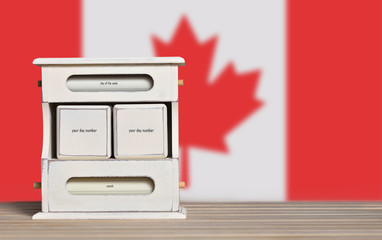 Fototapete - Wooden retro calendar with free space for a date on the background of the flag of Canada. Template for writing Canada national holiday dates with free text space