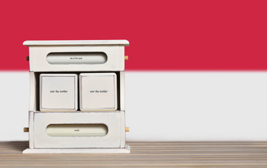 Fototapete - Wooden retro calendar with free space for a date on the background of the flag of Indonesia. Template for writing the dates of the national holidays of Indonesia with free text space
