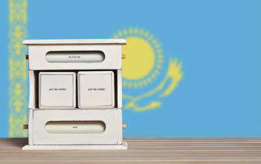 Fototapete - Wooden retro calendar with free space for a date on the background of the flag of Kazakhstan. Template for writing dates of national holidays of Kazakhstan with free text space